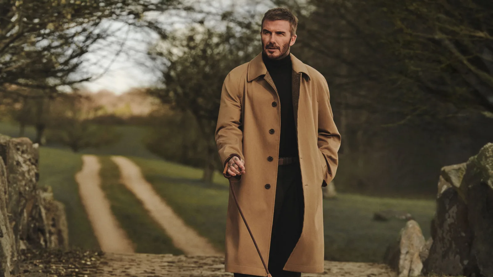 BOSS by Beckham de HUGO BOSS: David Beckham con abrigo camel y su perro en un camino rural